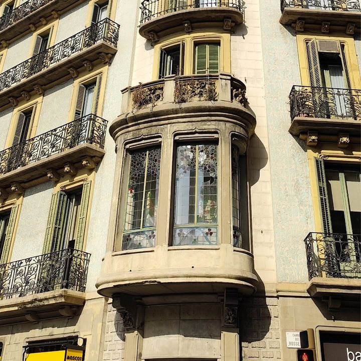 Tribuna de piedra con ventanales y balcones de hierro forjado