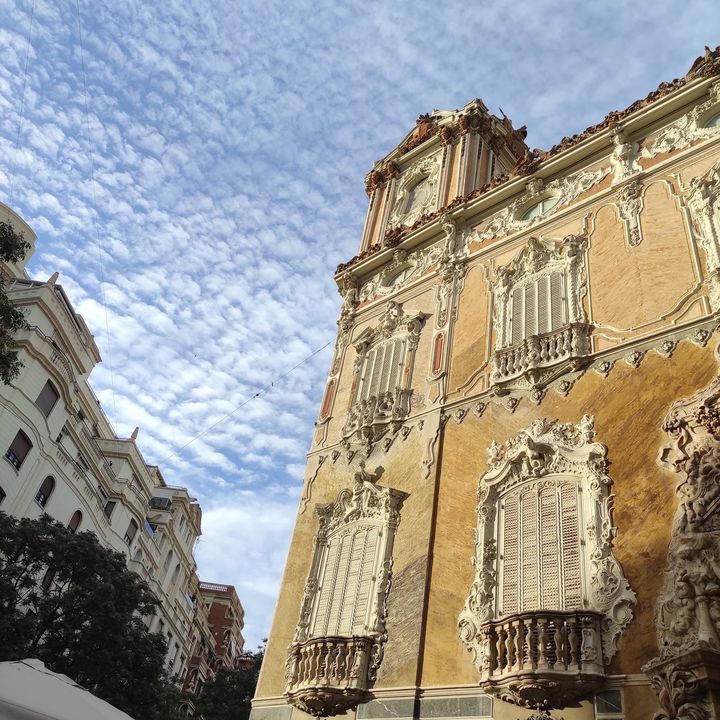 Fachada barroca de alabastro bajo un cielo de nubes