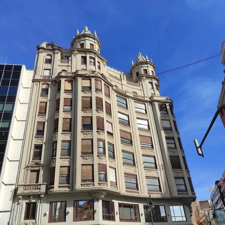 Edificio de viviendas con torretas en lo alto, contra el cielo azul